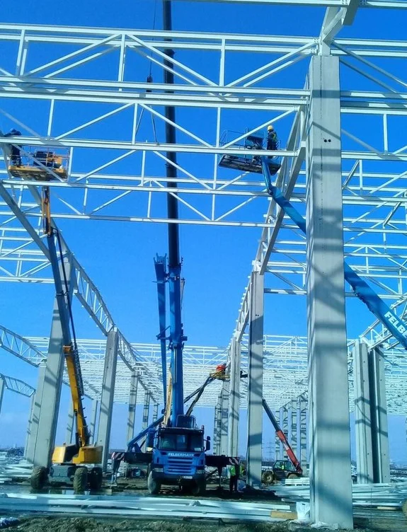 Mavi boyalı çelik taşıyıcıların vinçle montajı