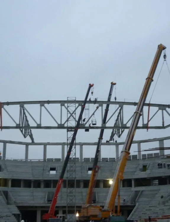 Vinçlerle stadyum çatı taşıyıcısının montajı